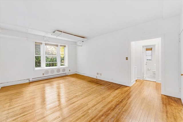 unfurnished room with light wood-type flooring and a baseboard radiator