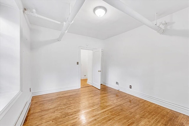 spare room with light hardwood / wood-style floors and a baseboard radiator