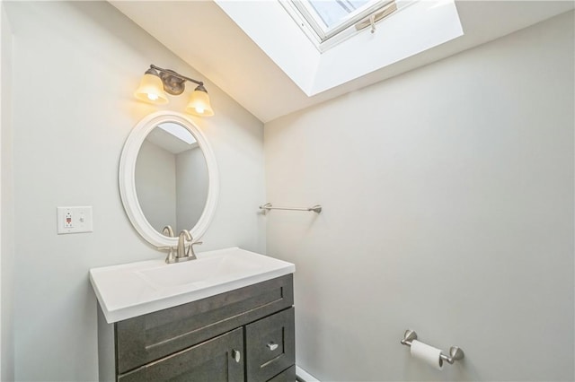 bathroom featuring vanity and vaulted ceiling with skylight