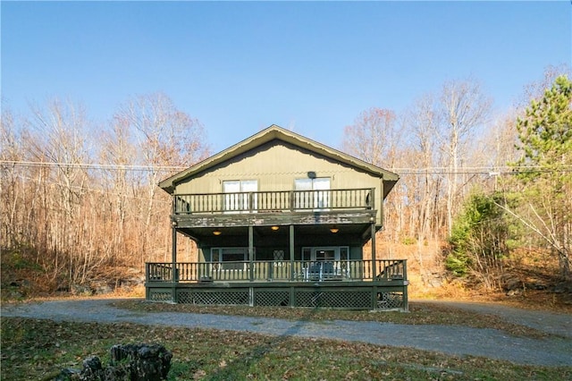 front of property featuring a balcony and a wooden deck