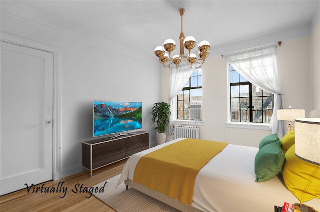 bedroom featuring wood-type flooring, an inviting chandelier, and radiator