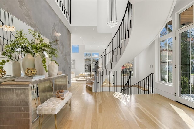 foyer featuring a notable chandelier, light hardwood / wood-style floors, and a high ceiling