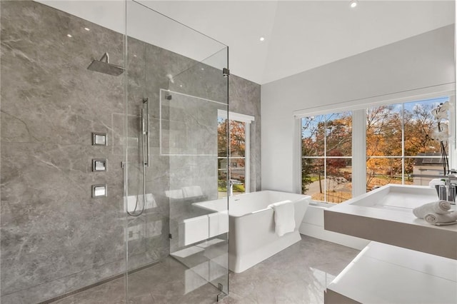 bathroom with plus walk in shower, vanity, and lofted ceiling