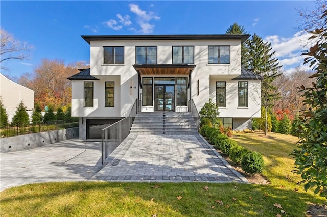 modern home featuring a front lawn and a garage