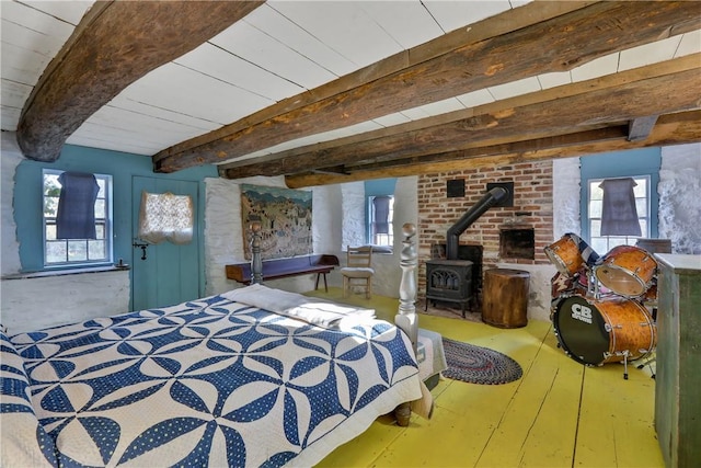 bedroom featuring beam ceiling and a wood stove