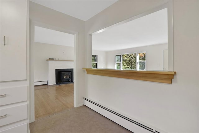 corridor with baseboard heating and light hardwood / wood-style floors