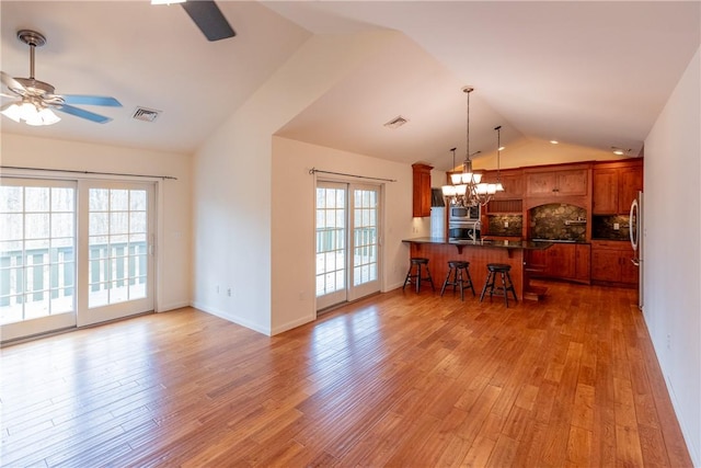 kitchen featuring ceiling fan with notable chandelier, kitchen peninsula, stainless steel appliances, and a wealth of natural light