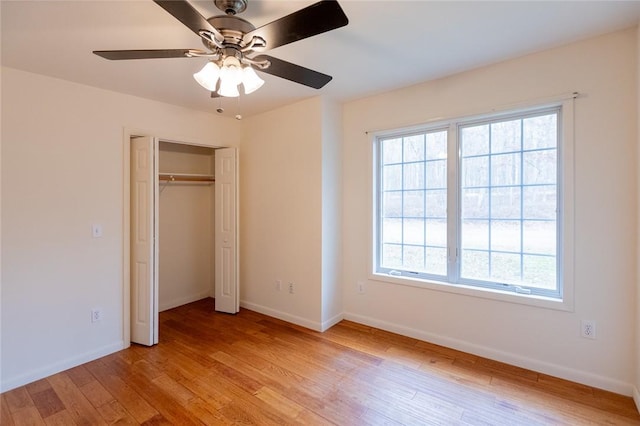 unfurnished bedroom with ceiling fan, light hardwood / wood-style floors, and a closet