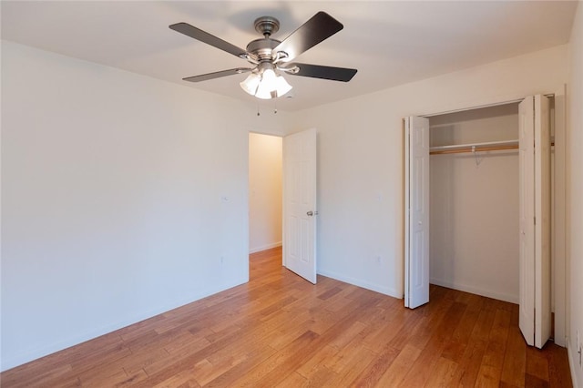 unfurnished bedroom with a closet, light hardwood / wood-style flooring, and ceiling fan