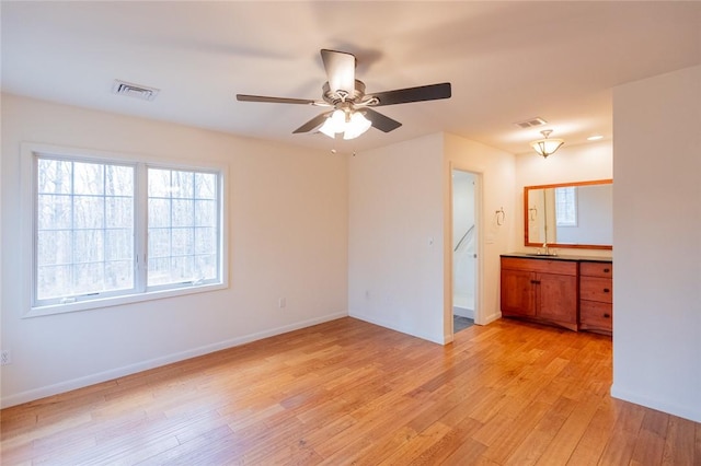 interior space with ceiling fan, light hardwood / wood-style floors, and sink