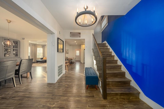 stairway featuring a chandelier and wood-type flooring