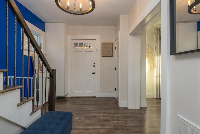 entryway with dark hardwood / wood-style flooring and a chandelier