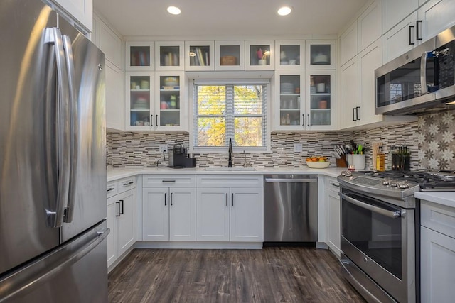 kitchen featuring tasteful backsplash, stainless steel appliances, sink, dark hardwood / wood-style floors, and white cabinetry