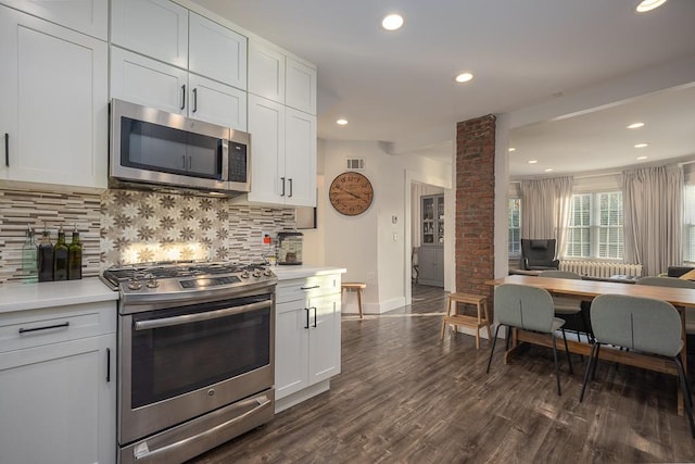 kitchen with ornate columns, white cabinets, and appliances with stainless steel finishes