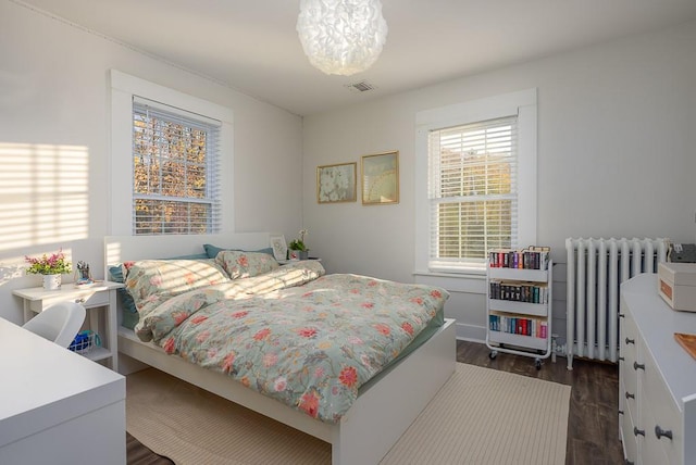 bedroom with radiator and dark hardwood / wood-style flooring