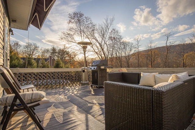 deck at dusk featuring an outdoor living space and a grill