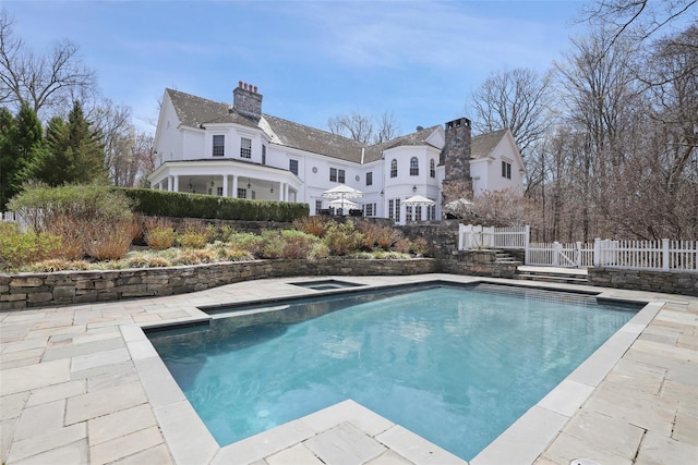 view of swimming pool featuring fence, a fenced in pool, and an in ground hot tub