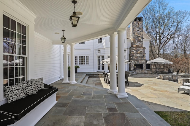 view of patio with exterior kitchen and an outdoor stone fireplace