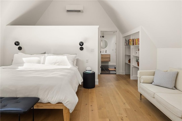 bedroom featuring a wall mounted air conditioner, wood-type flooring, and vaulted ceiling