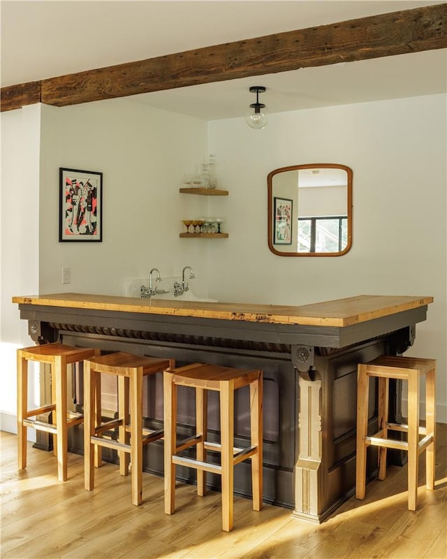 bar with beam ceiling and light wood-type flooring