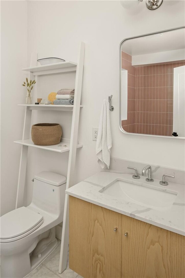 bathroom with a shower, vanity, and toilet