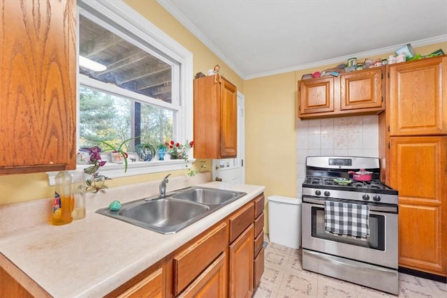 kitchen with sink, backsplash, crown molding, and stainless steel gas range