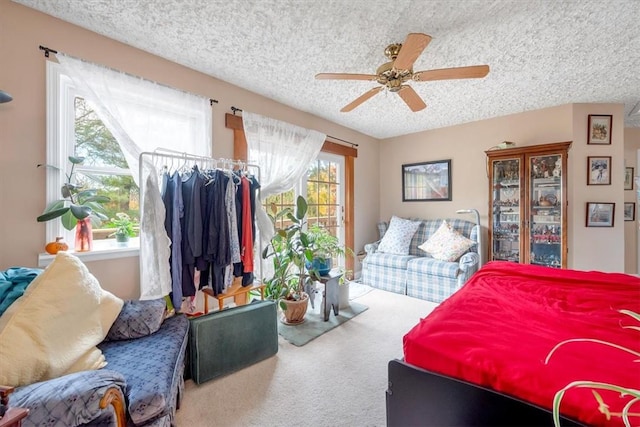 carpeted bedroom with ceiling fan and a textured ceiling