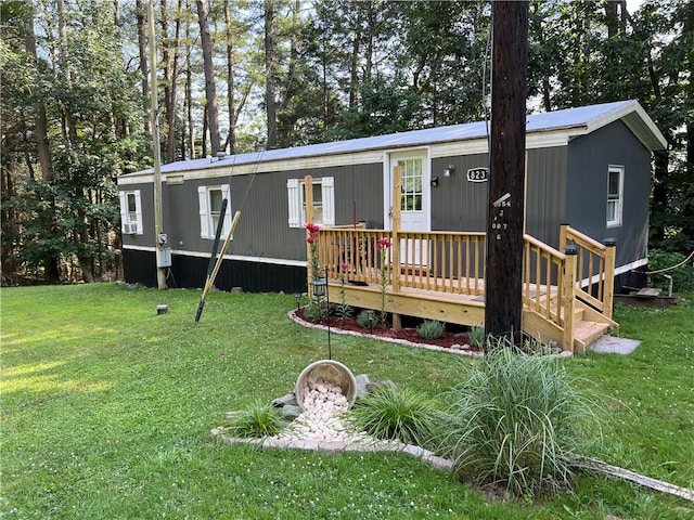 back of house with a wooden deck and a lawn