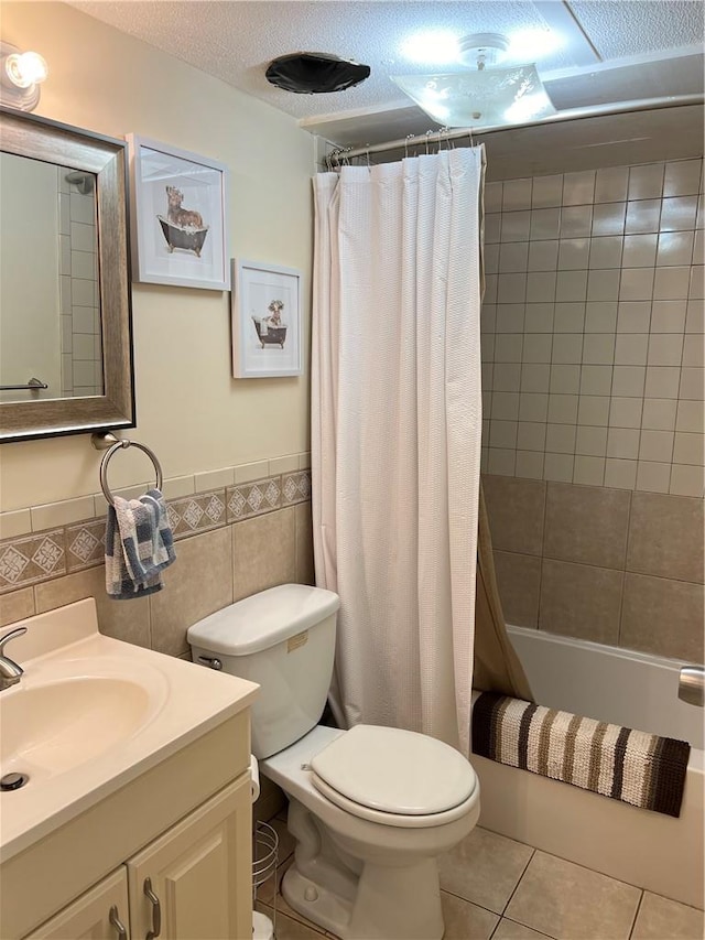 bathroom featuring tile patterned flooring, toilet, and washer / dryer