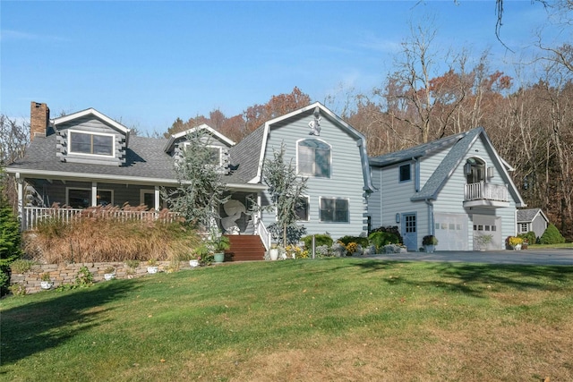 view of front of house featuring a garage, a shingled roof, a gambrel roof, a chimney, and a front yard