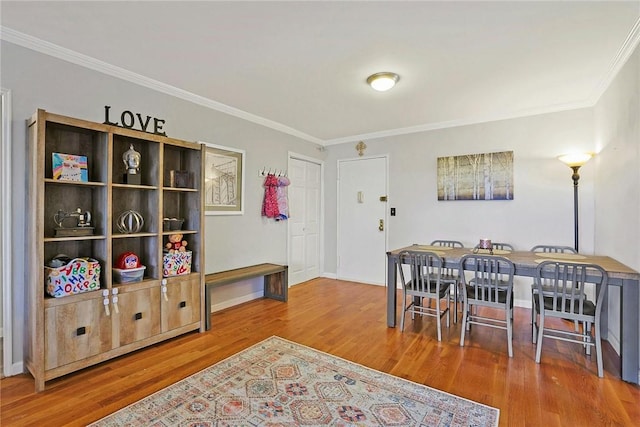 dining space with hardwood / wood-style floors and ornamental molding