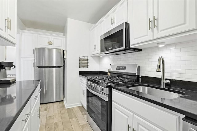 kitchen featuring white cabinets, stainless steel appliances, light hardwood / wood-style flooring, and sink