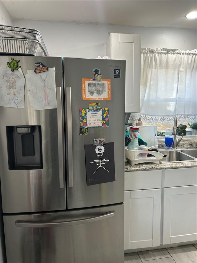 kitchen with white cabinets and stainless steel fridge