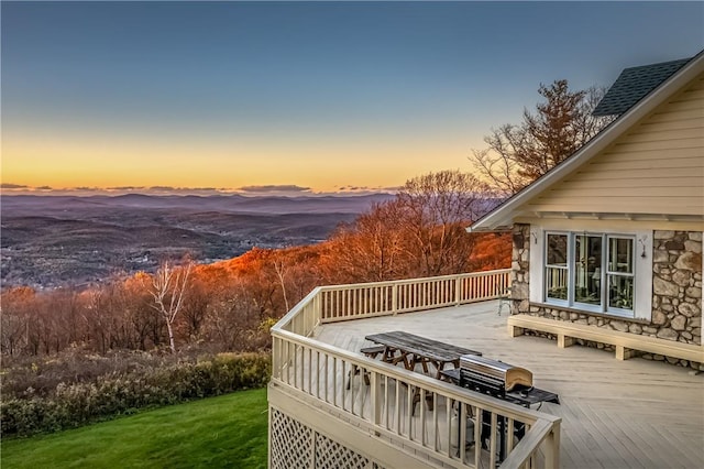 deck at dusk featuring a mountain view