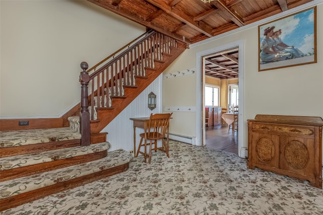 staircase with beam ceiling, wood ceiling, and a baseboard heating unit