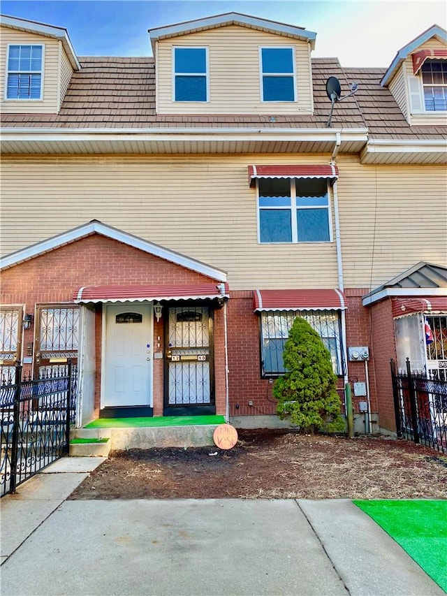 townhome / multi-family property featuring brick siding and fence