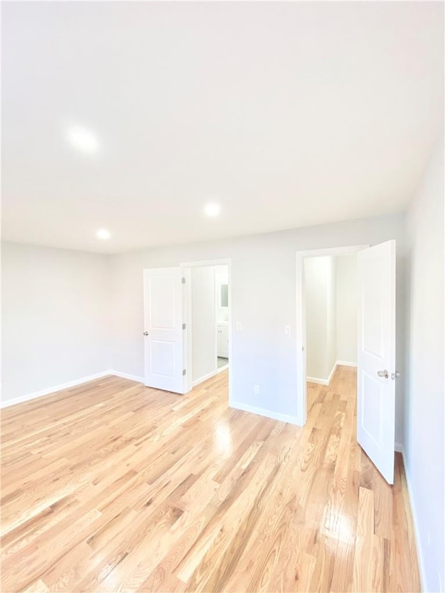 spare room featuring recessed lighting, light wood-style flooring, and baseboards