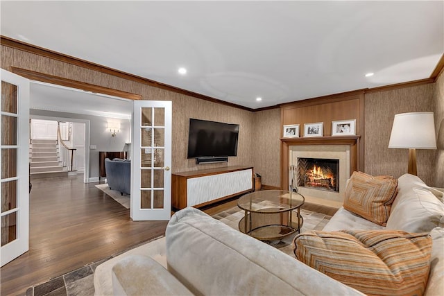 living room featuring french doors, crown molding, and hardwood / wood-style flooring