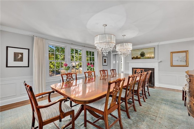 dining area with crown molding, wood-type flooring, and a notable chandelier