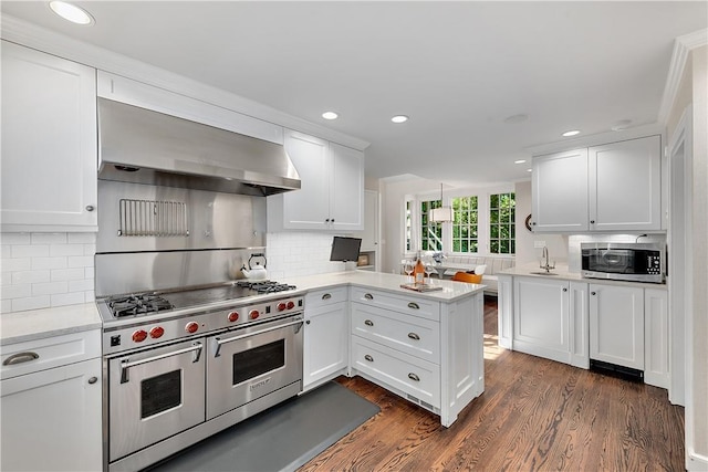 kitchen featuring appliances with stainless steel finishes, white cabinetry, ventilation hood, dark hardwood / wood-style flooring, and kitchen peninsula