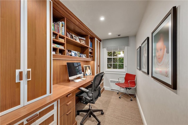 office with built in desk and light carpet