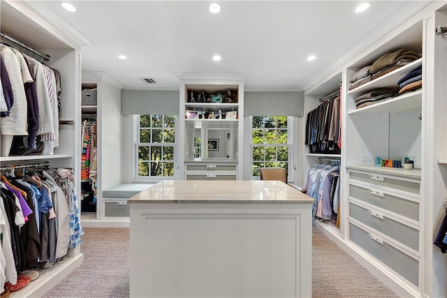 walk in closet featuring light colored carpet