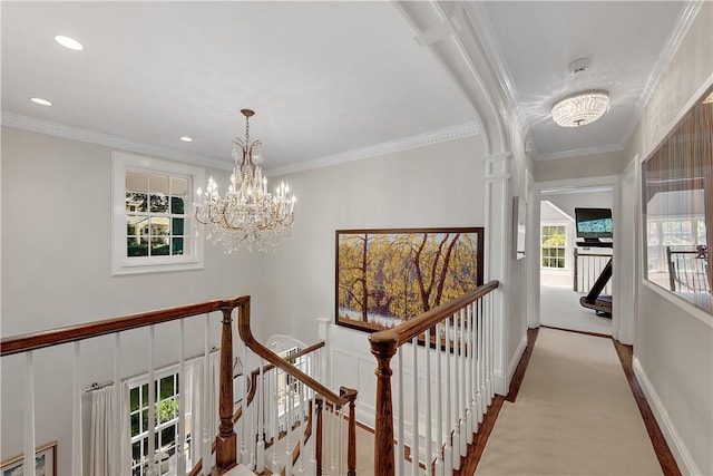 hall with an inviting chandelier and ornamental molding