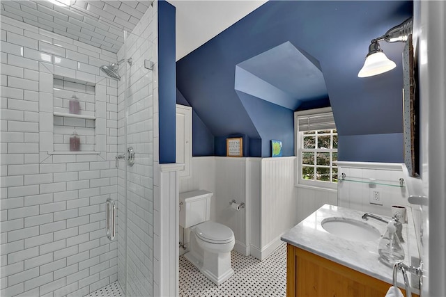 bathroom with a shower with door, vanity, lofted ceiling, and toilet