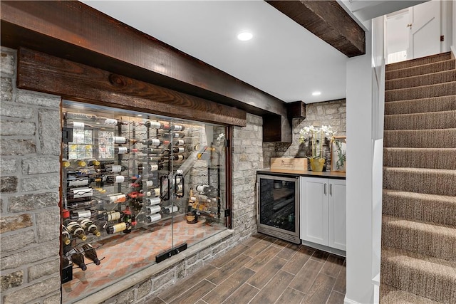 bar featuring white cabinetry, beverage cooler, and beam ceiling