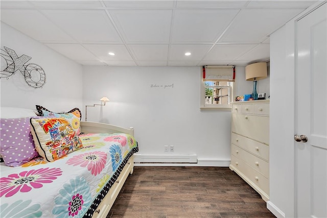 bedroom featuring dark hardwood / wood-style flooring, a baseboard heating unit, and a paneled ceiling