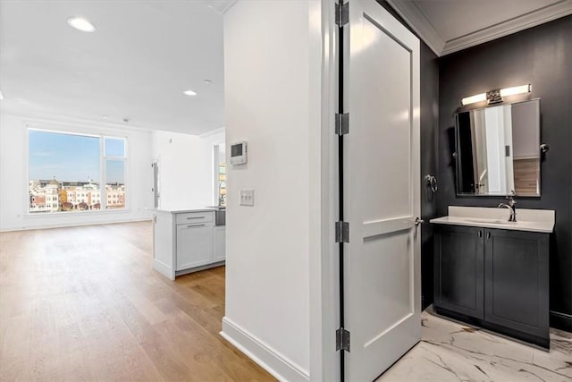 bathroom featuring recessed lighting, wood finished floors, vanity, baseboards, and crown molding