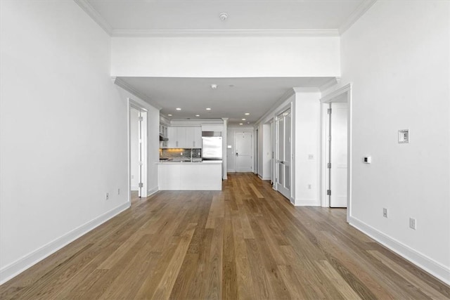 unfurnished living room with hardwood / wood-style floors and ornamental molding