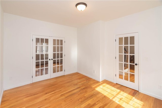 unfurnished room featuring french doors and light hardwood / wood-style flooring