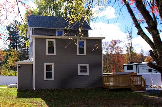 rear view of house featuring a yard and a wooden deck